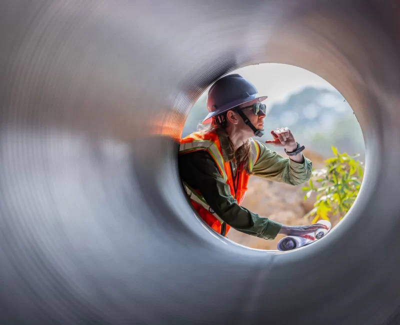 a-female-engineer-examines-a-large-drainage-pipe-2025-06-28-07-29-04-utc